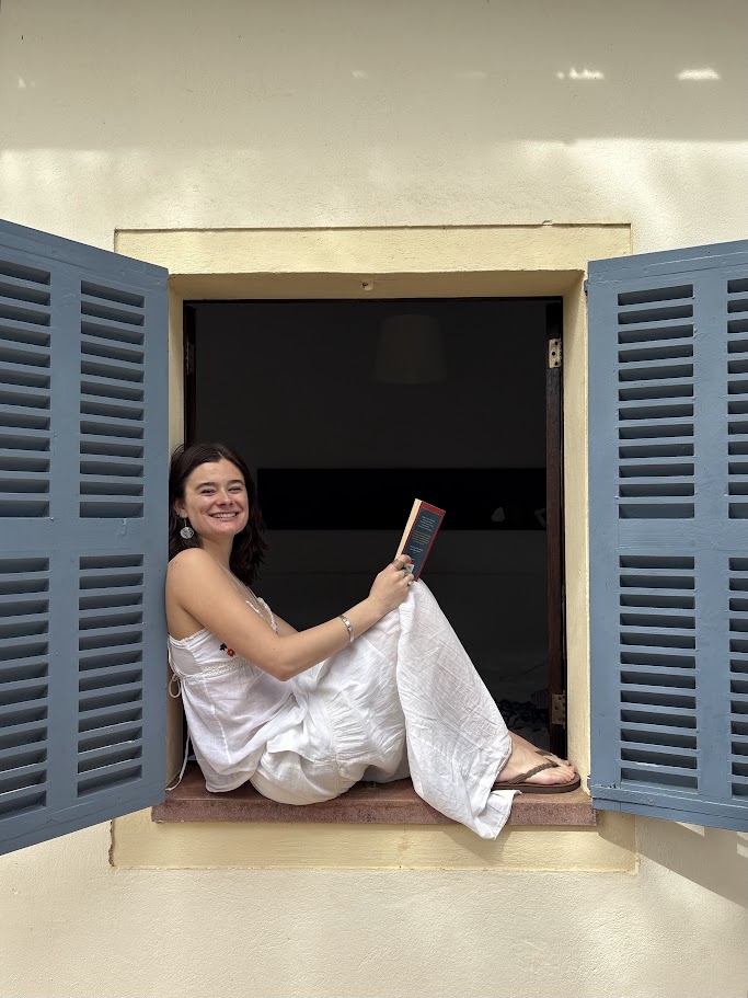 Student sits on a window in Italy 