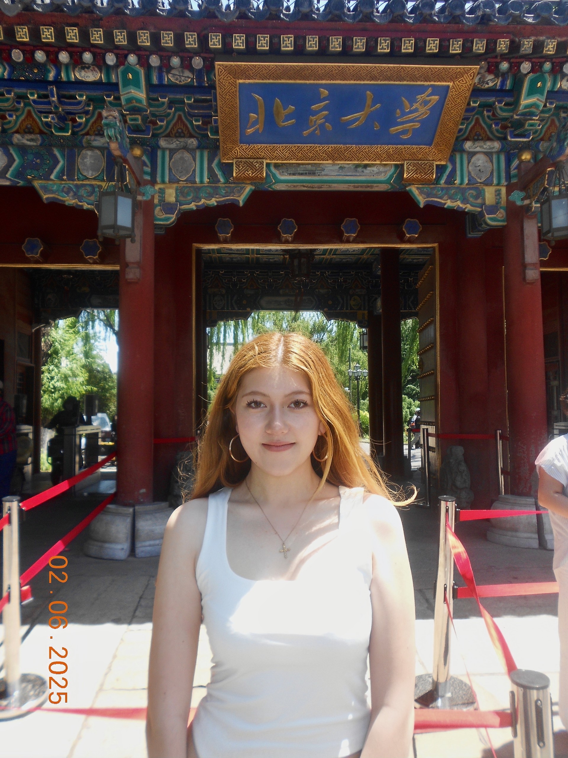 College woman standing smiling in front of building in China 