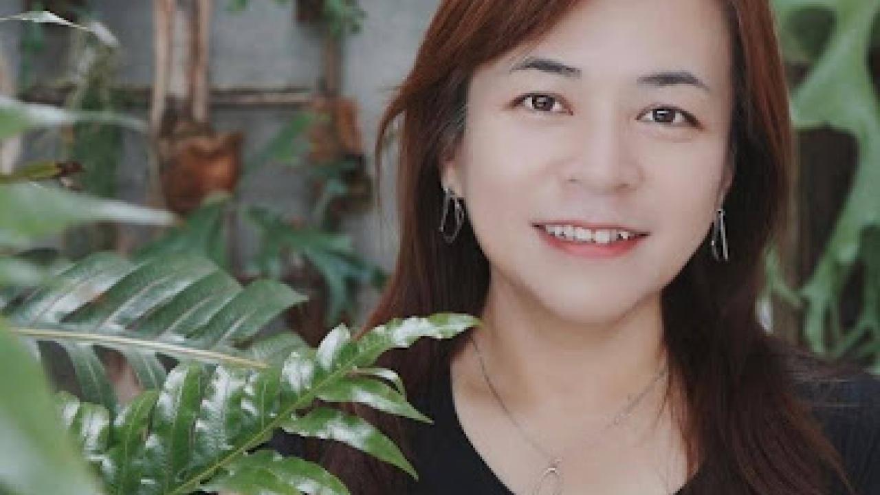 Trisha Lin standing in front of a plant