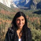 Headshot of Camila Alviar. Redwood trees are behind Camila, in the distance